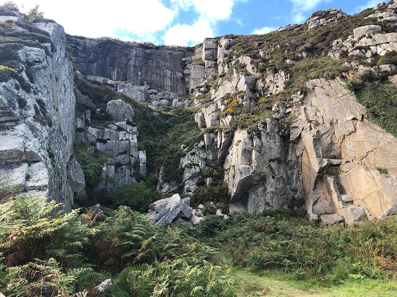 Broken granite faces and fallen blocks of the old quarry on Lundy's east sidelands, half swallowed by bracken.