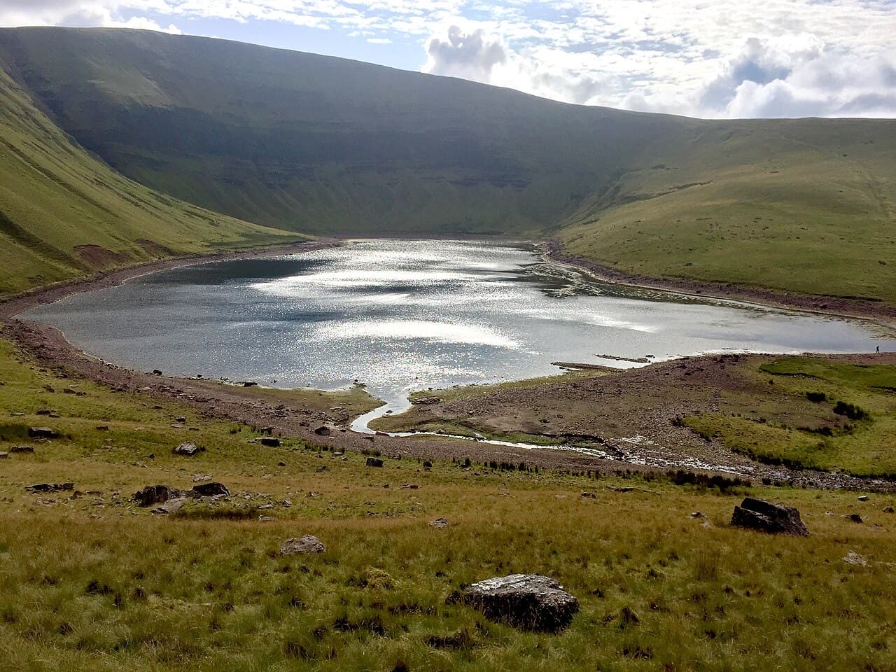 Silver light scatters across Llyn y Fan Fach beneath the sweeping headwall of the Black Mountain.