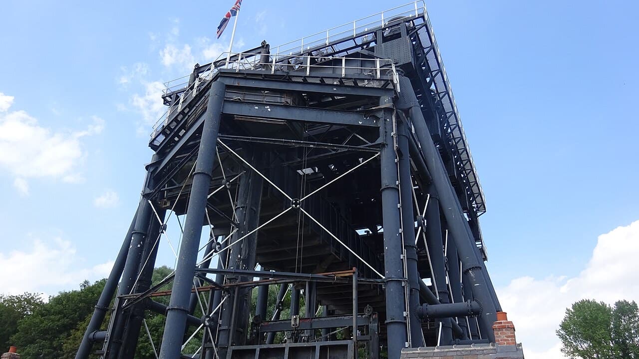 Looking up from the base of the Anderton Boat Lift into its towering frame of girders and columns against a blue sky.