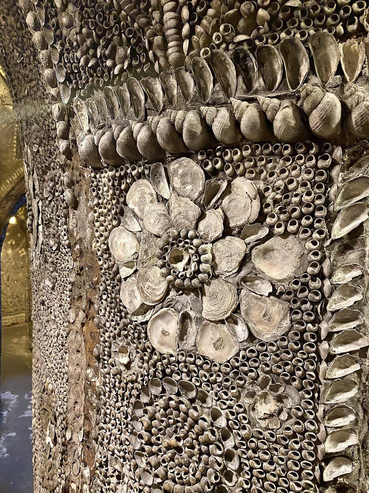 Close-up of a rosette of oyster shells ringed by borders of whelks, mussels and winkles on a mosaic pilaster.